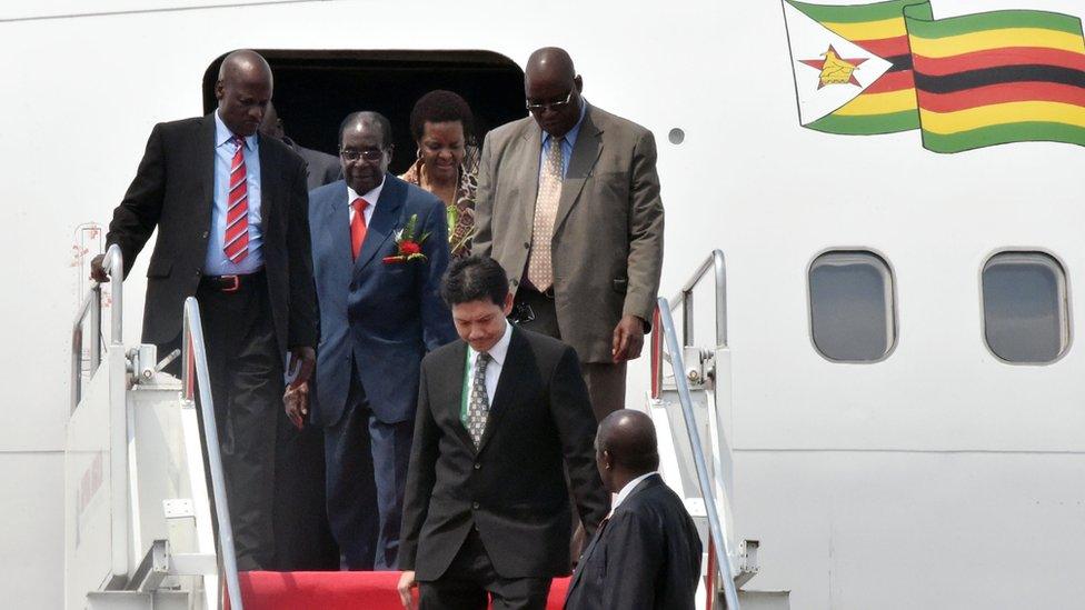 Zimbabwe's President Robert Mugabe (second on the left) disembarks from an aircraft after arriving at Halim airport in Jakarta (21 April 2015)