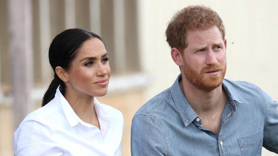 Harry and Meghan, looking concerned