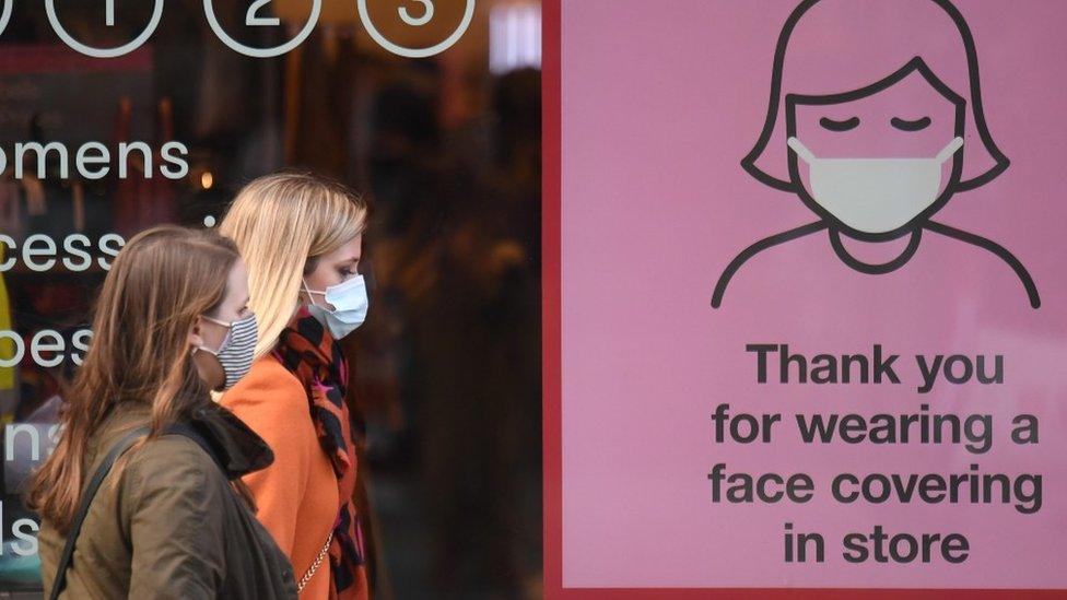 People in masks and face covering sign