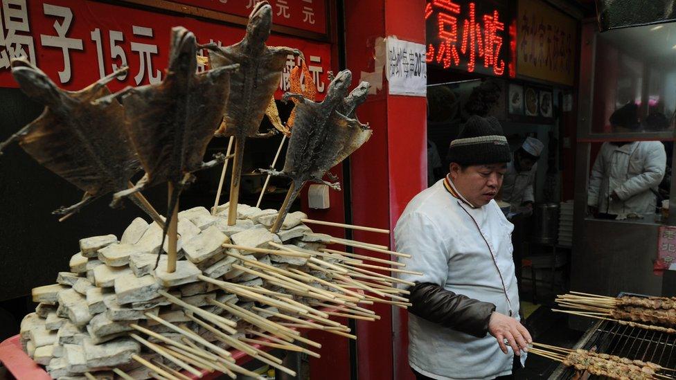 A street hawker cook lizards at his stall in the Wangfujing shopping street of Beijing on January 17 2012.