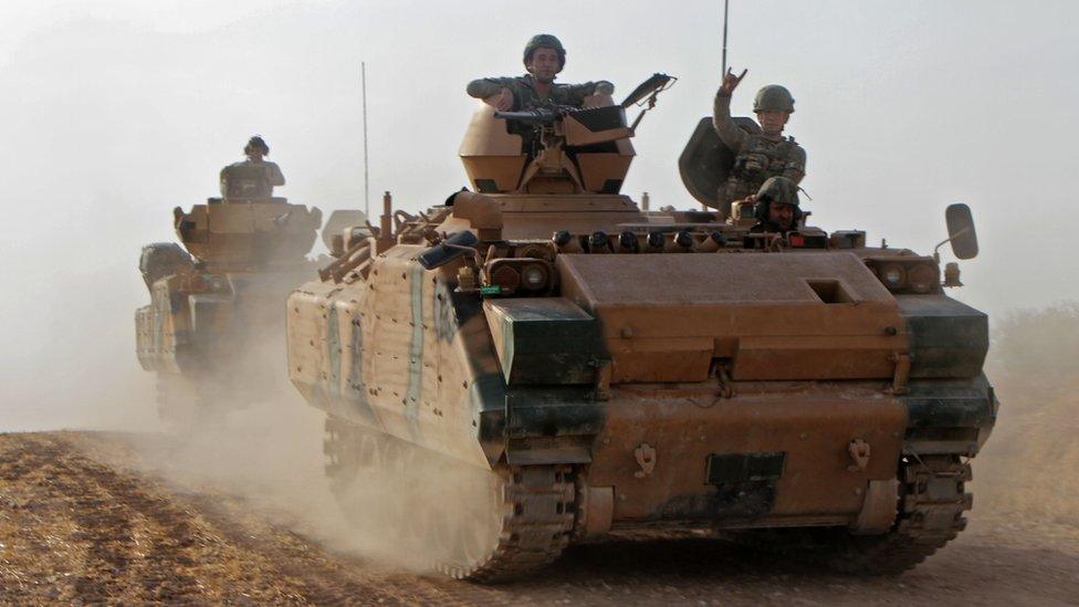 Turkish soldiers are transported in armoured personnel carriers through the town of Tukhar, north of Syria's northern city of Manbij, on October 14, 2019