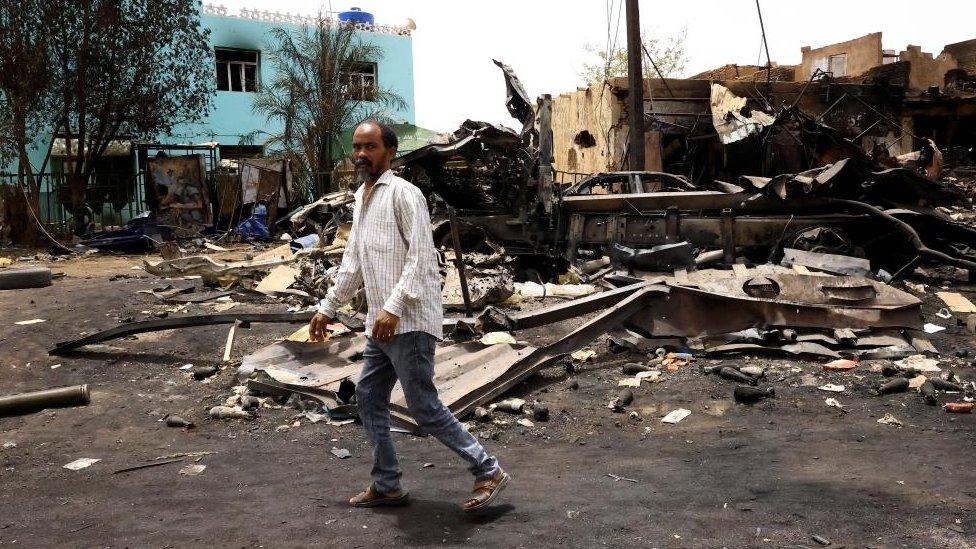 Men walk past shells on the ground near damaged buildings at the central market during clashes between the paramilitary Rapid Support Forces and the army in Khartoum North, Sudan April 27, 2023