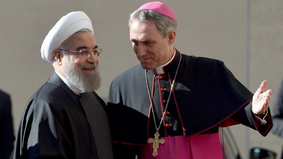 The prefect of the papal household bishop Georg Gaenswein (R) welcomes Iranian President Hassan Rouhani in Rome