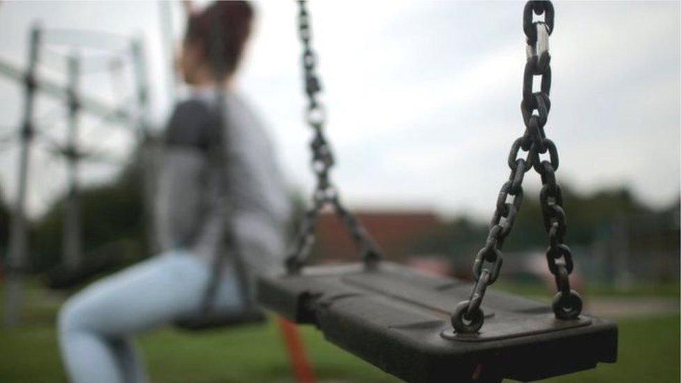 Person sitting on a swing in a park