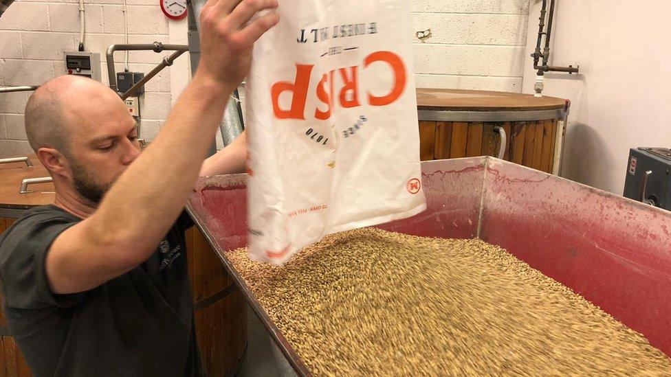 Sam from Goffs Brewery pouring in beer ingredients