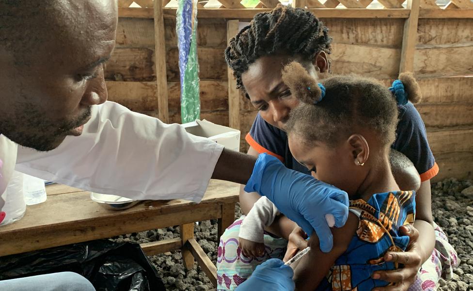 A handout photo made available by the World Health Organization (WHO) shows a child receiving a vaccination for measles at a health center in Goma