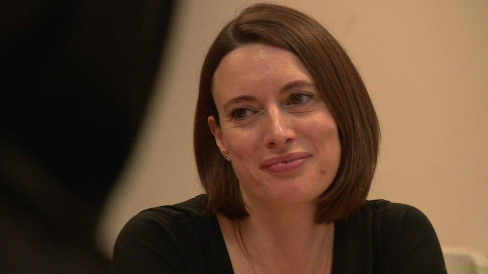 Image showing Catherine Skinner smiling as she listens to one of her clients speak during a meeting