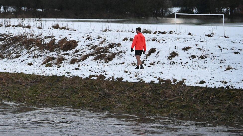 Man walks past River Mersey in Didsbury