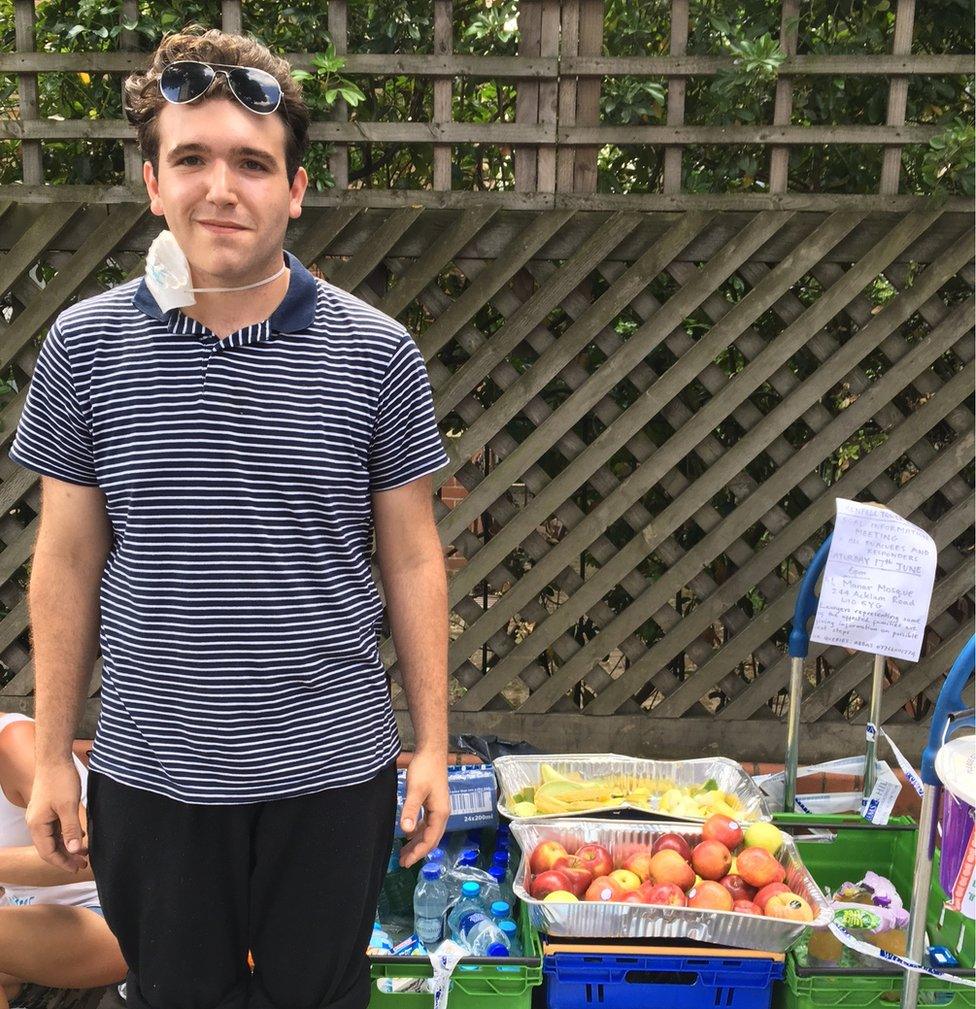 Reece Lusmore next to a trolley of fruit and drinks