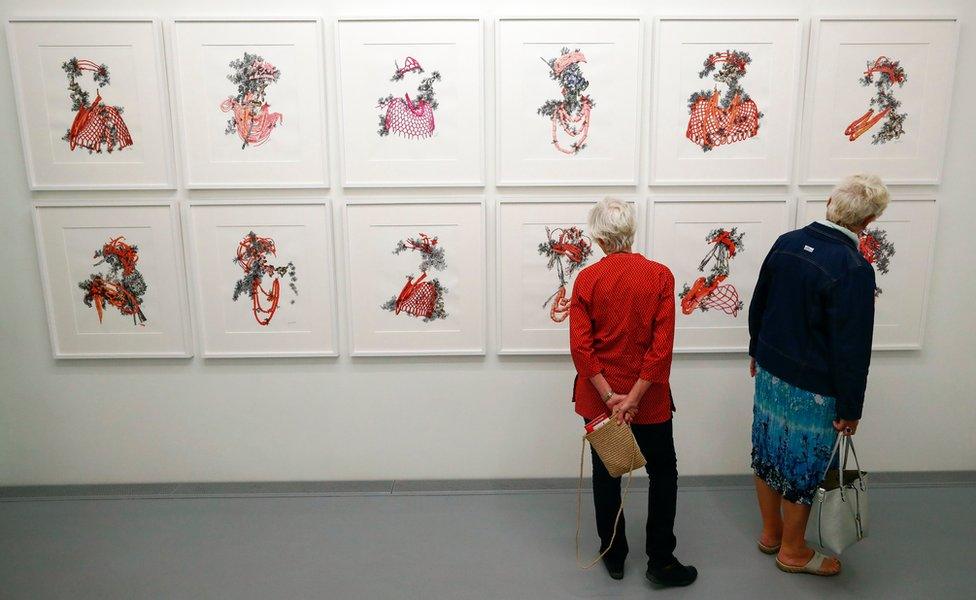 Two women look at artworks by Nigerian artist Taiye Idahor on exhibit at the Zeitz Museum of Contemporary Art Africa (Zeitz MOCAA) at the V&A Waterfront in Cape Town, South Africa 15 November 2017