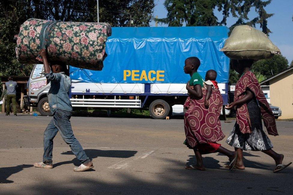 Asylum seekers walk with their belongings to Bunagana town in Uganda.