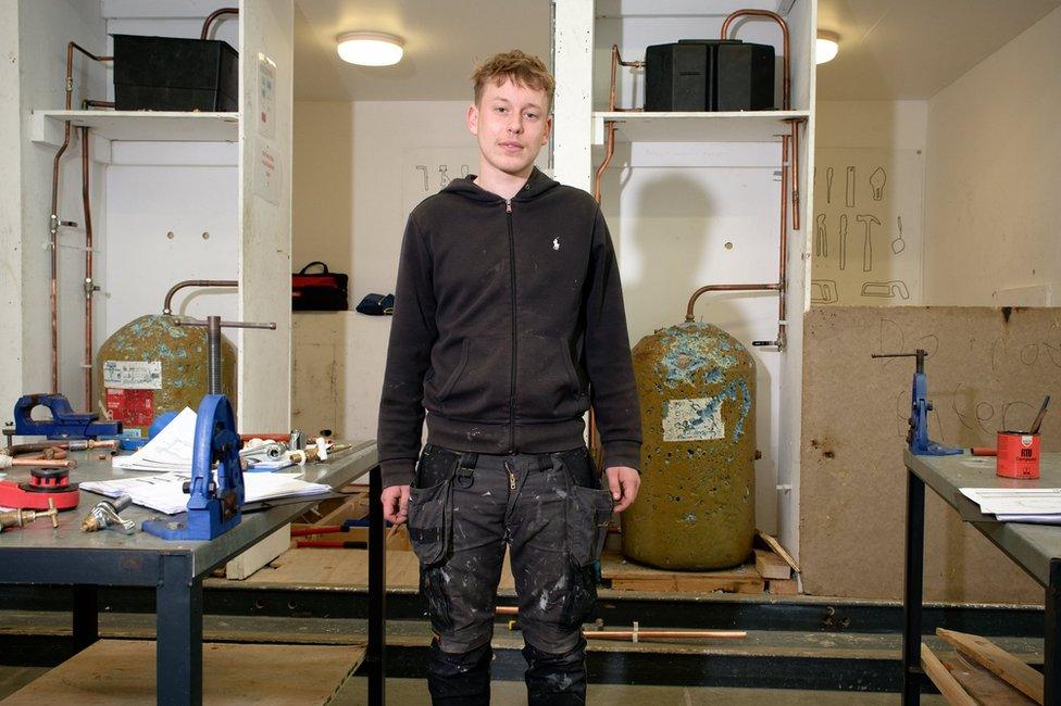 Justin Rowe poses in front of hot water tanks