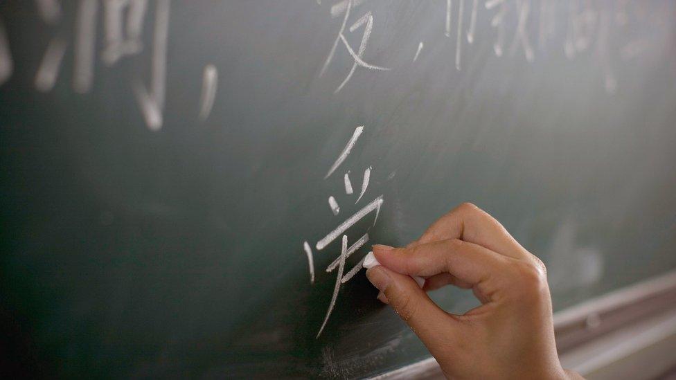 A teacher writes the Chinese character of "Love" during a class at a school in Dujiangyan, Sichuan province, China, 1 June 2008