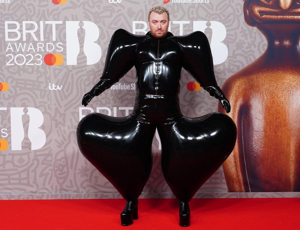 Sam Smith on the Brit Awards red carpet in black inflatable latex suit designed by Harri