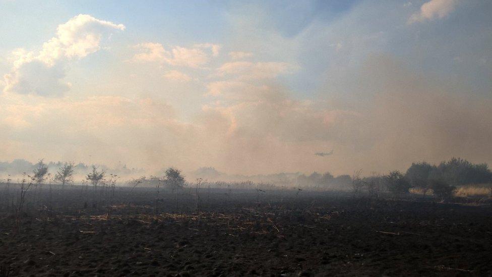 An airplane seen through the smoke from the fire