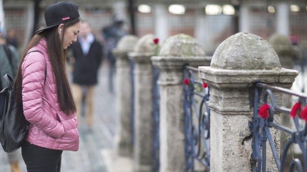 A woman pays tribute to victims who were killed in an explosion near by Blue Mosque at Ottoman era in Istanbul (13 January 2016)