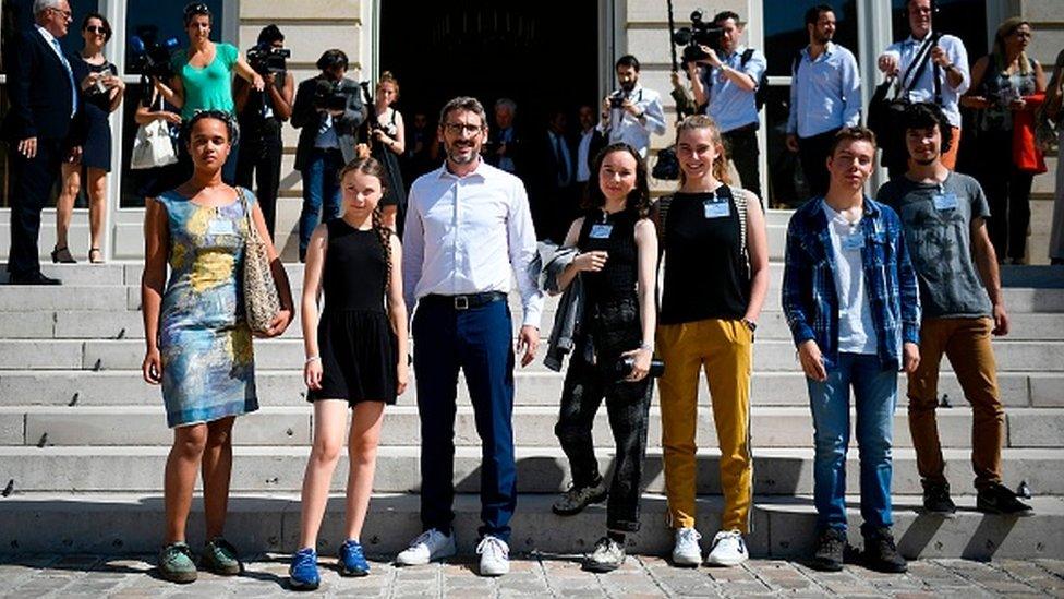 Greta Thunberg and other youth climate activists stand outside France's parliament