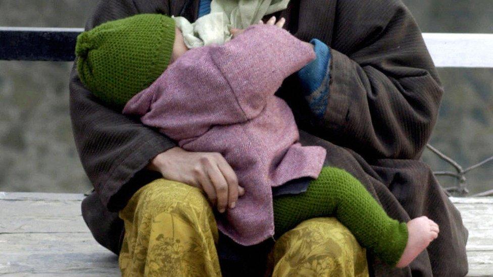 A woman breastfeeds her baby in India.