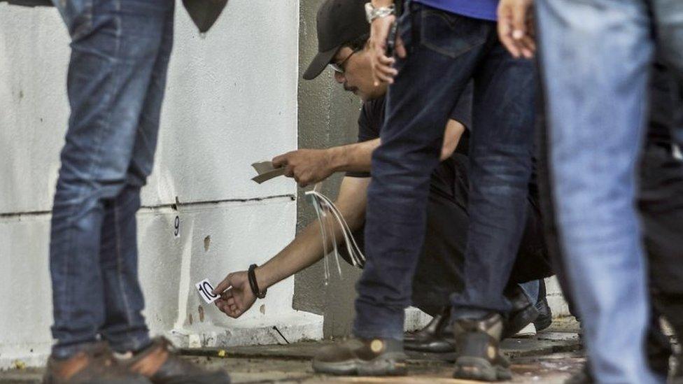 Royal Malaysian Police (RMP) forensic officers collect evidence at the crime scene where a Palestinian scientist was shot dead on 21 April