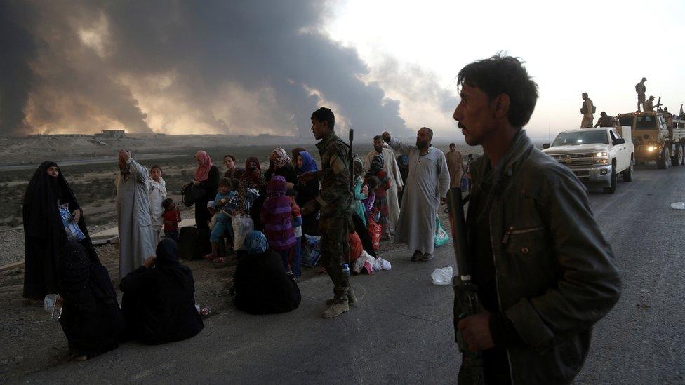 People flee their homes during fighting between Iraqi security forces and IS near Mosul, 18 October