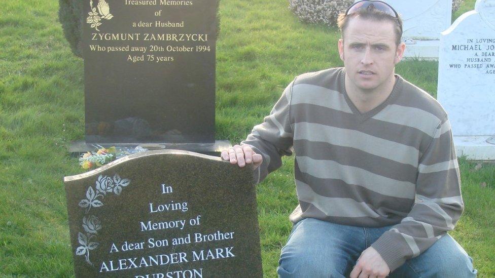 Daniel Durston kneels by his brother Alex's grave