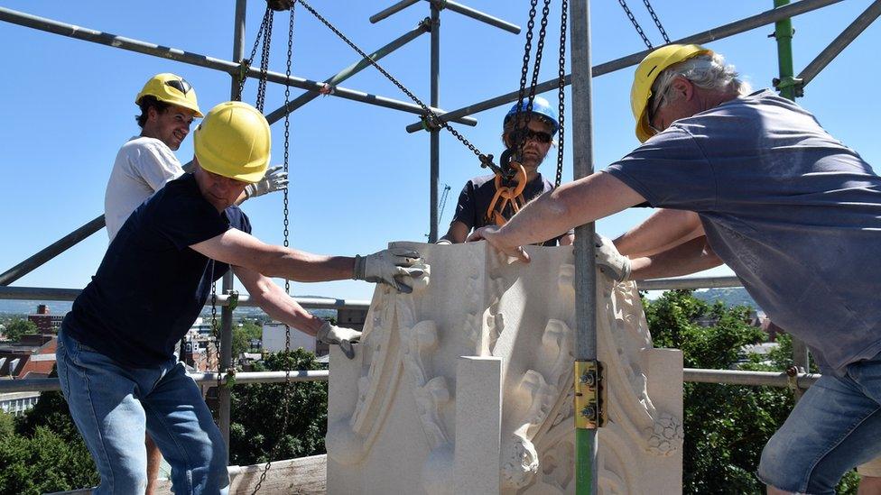 Stonemason lifting a pinnacle