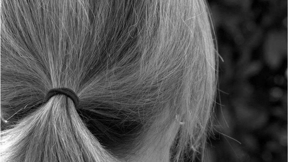 Stock image of woman's hair tied back