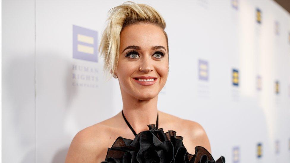 This is a photo of Katy Perry smiling on a red carpet.