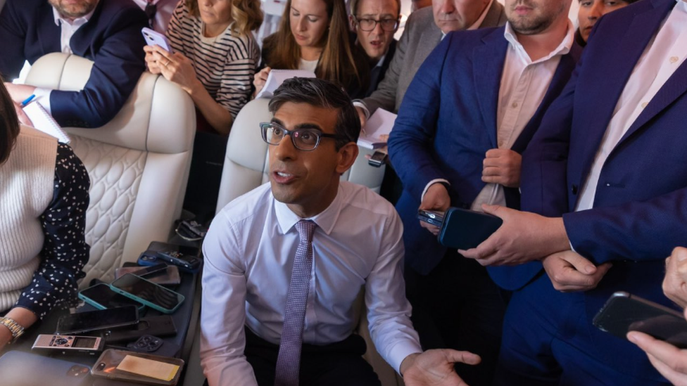 Rishi Sunak speaking to reporters on the plane to Washington DC