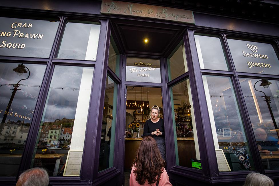 A member of staff telling people the bar is full at The Moon and Sixpence, Whitby