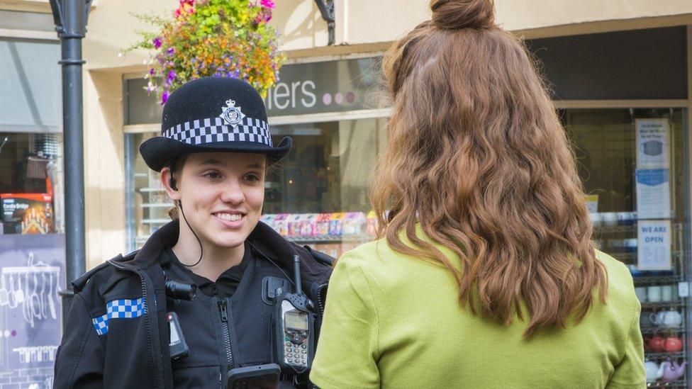 Police officer speaking to woman