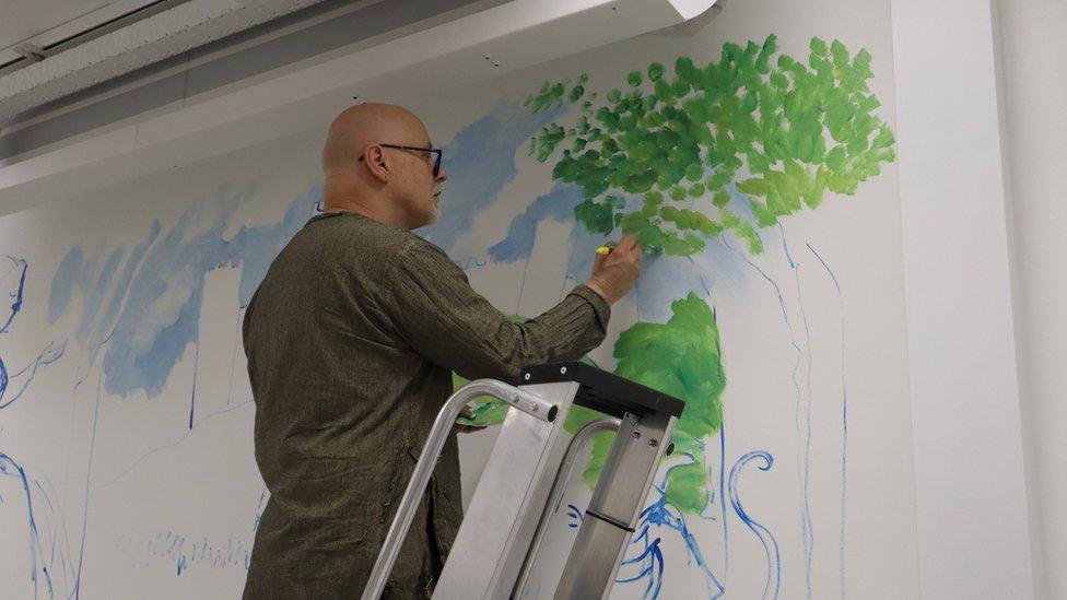 James Mayhew painting the mural at West Suffolk Hospital