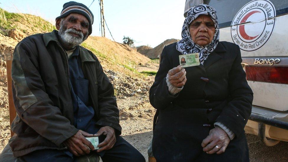 A Pakistani couple sit next to a Syrian Arab Red Crescent (SARC) ambulance as they prepare to leave the rebel-held Eastern Ghouta town of Douma, Syria (28 February 2018)