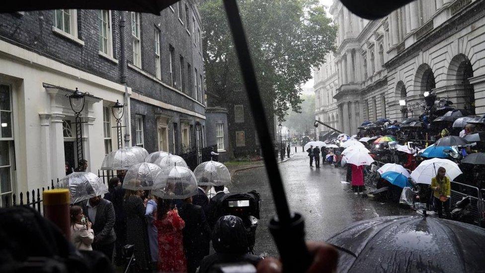 People wait in the rain in Downing Street