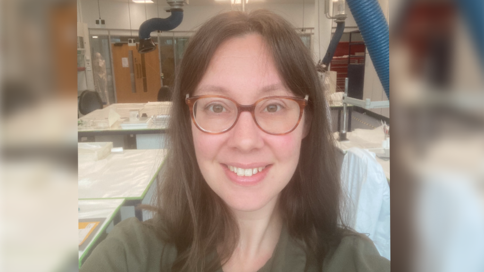 Kayleigh smiling at the camera in a conservation studio