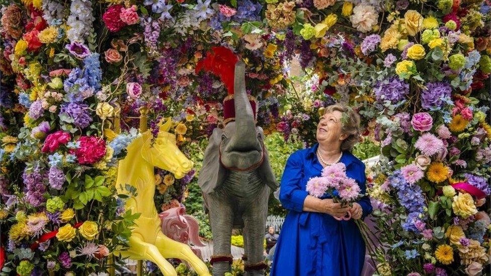 Florist Judith Blacklock puts the finishing touches to a floral carousel installation in Halkin Arcade, which she has designed with Neill Strain for the Belgravia in Bloom festival