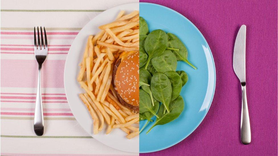 Plate - half with chips and burger the other half with spinach leaves