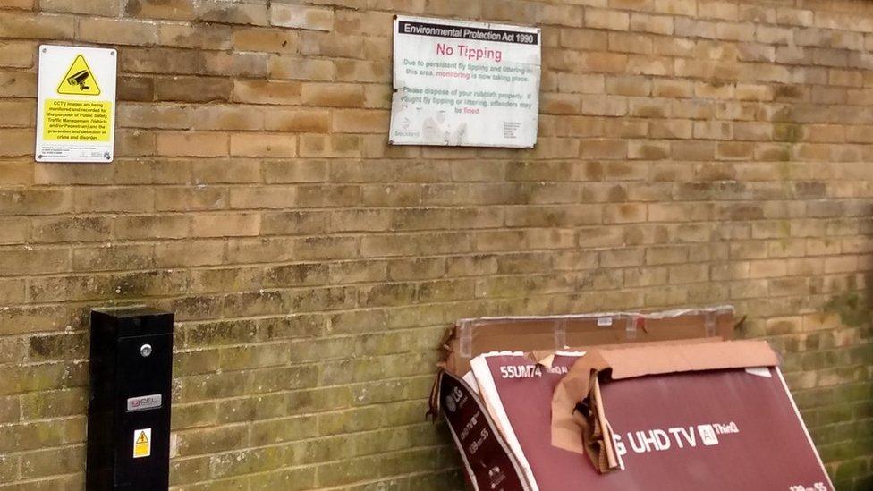 Old TV dumped under a "no tipping" sign at a Breckland Council office car park