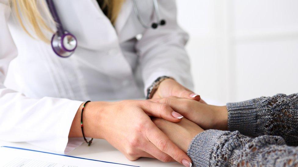 Doctor holding patient's hands