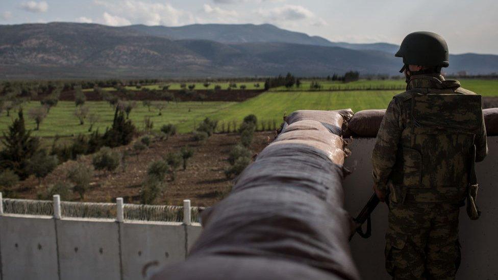 Turkish soldier stands watch at border with Syria
