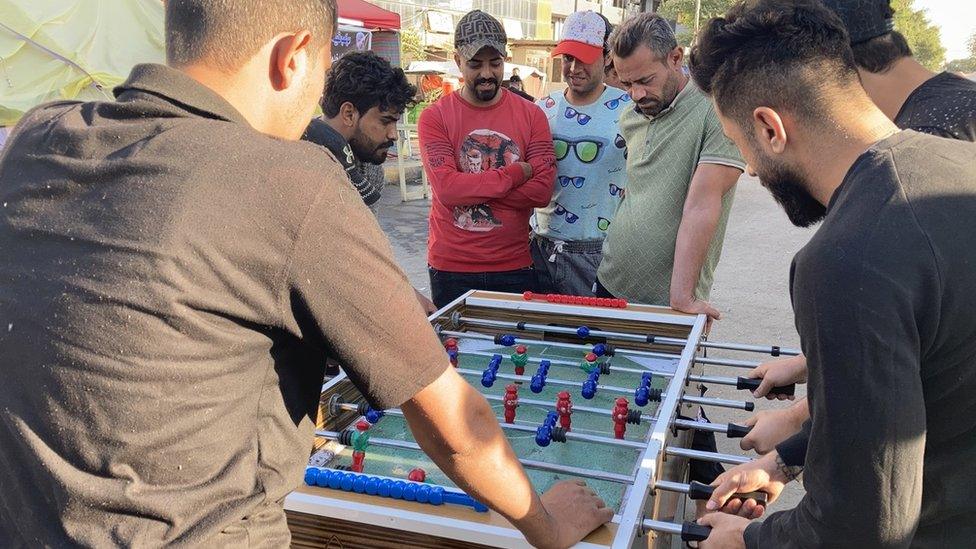 Men play table football at a protest camp set up by supporters of Iran-backed Shia Muslim militias in Baghdad, Iraq