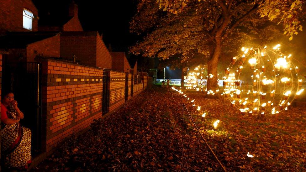 A woman looks at a fire garden before the switching on of Diwali lights in Leicester