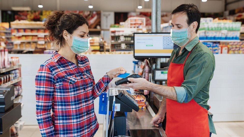 A customer pays at a supermarket till using her credit card