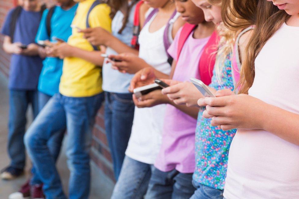 children holding phones