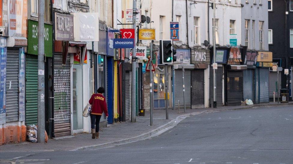 woman walking past closed shops