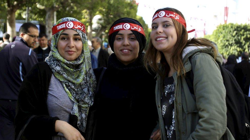 Three girls pose for a photo in Tunis, Tunisia, during a rally to celebrate the fifth anniversary of the Arab Spring