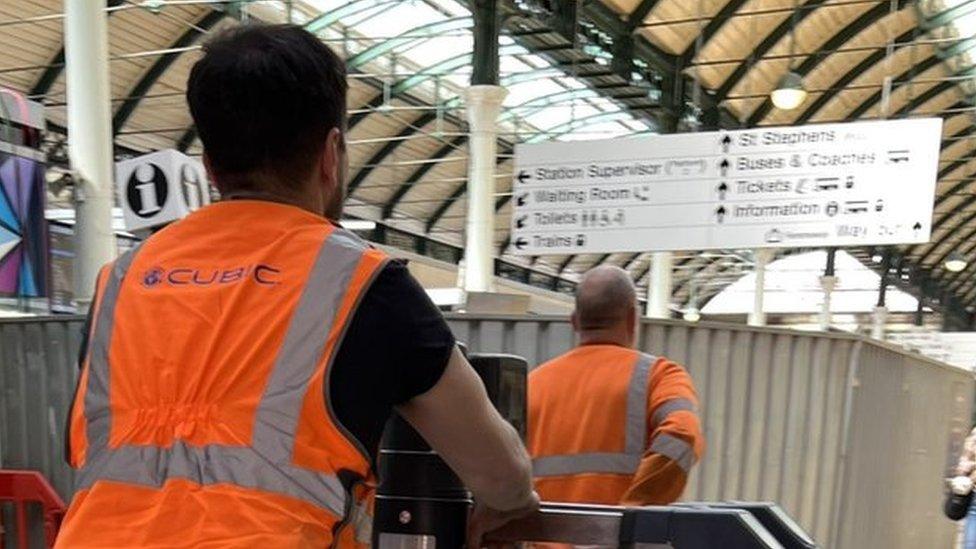 Workers installing ticcket barriers in Hull