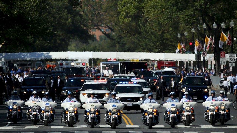 Pope Francis inside a large security motorcade