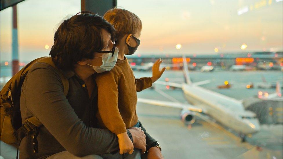 father-and-son-in-airport-wearing-masks