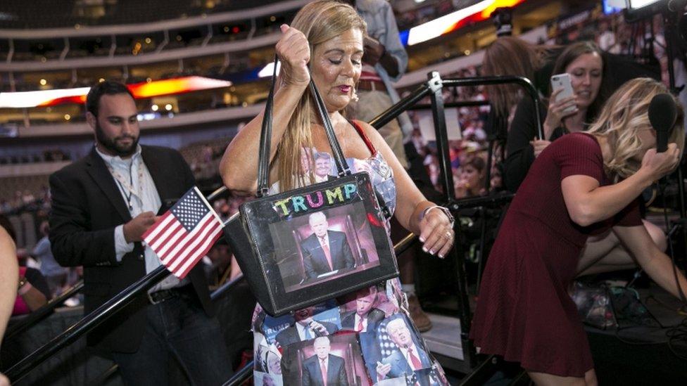 A woman wears a dress covered in printouts of US Republican presidential candidate Donald Trump's face during a campaign rally at the American Airlines Center in Dallas